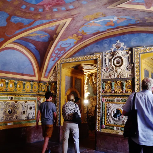 Painted vaulted grotto on the Hellbrunn fountain tour with visitors