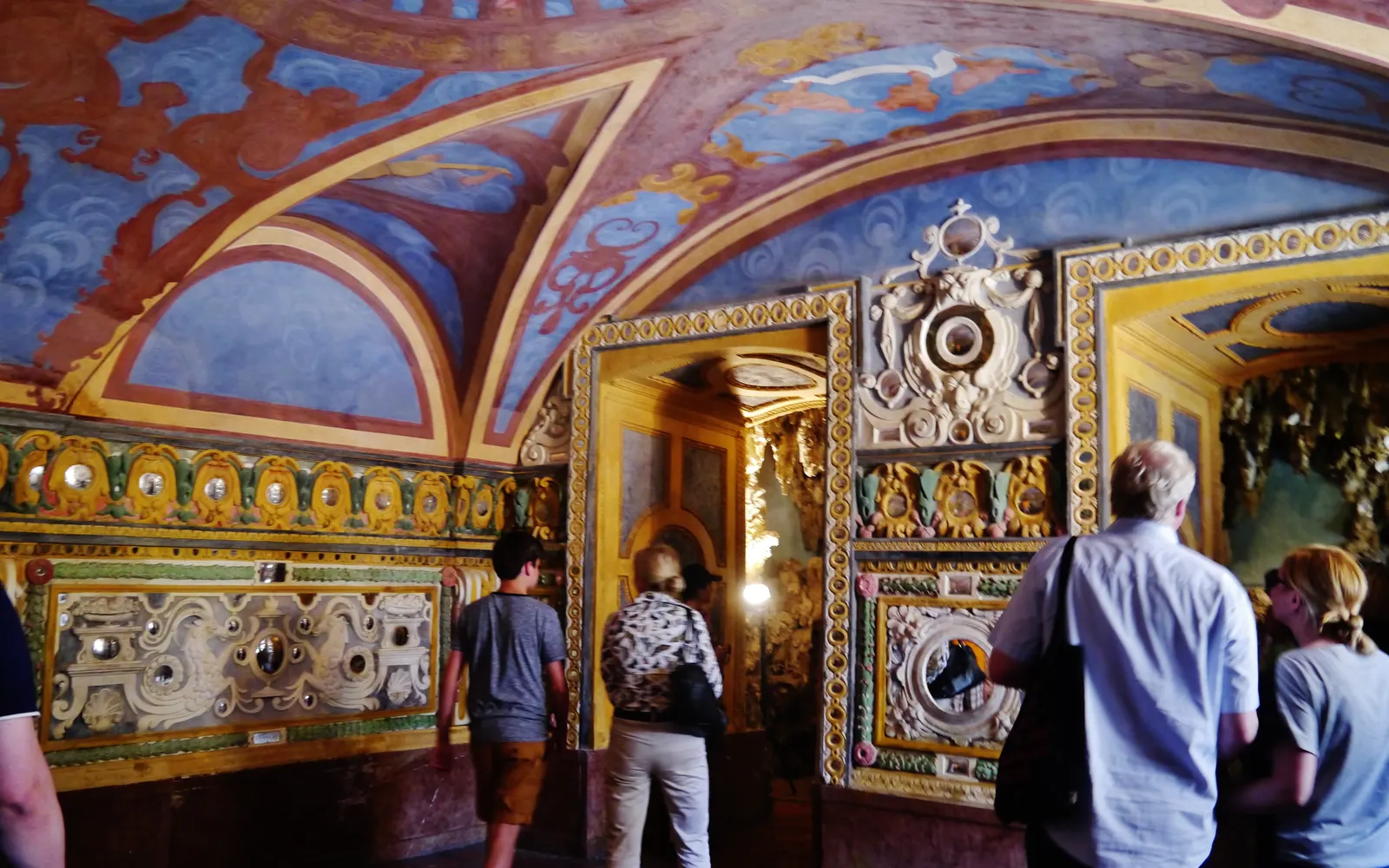 Painted vaulted grotto on the Hellbrunn fountain tour with visitors
