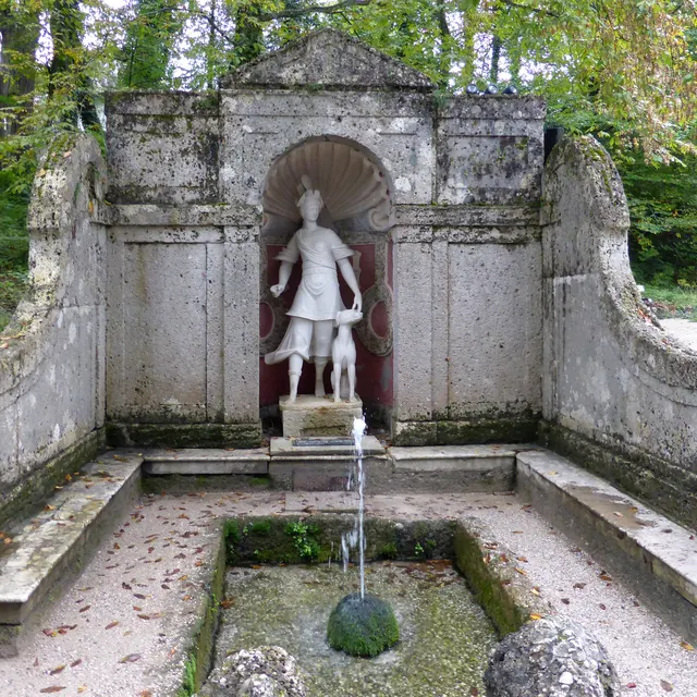 A statue in a stone niche fountain on the Hellbrunn tour